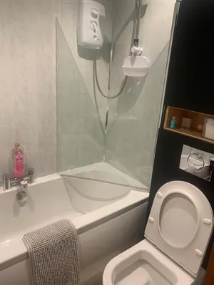 a bathroom with a shower and a toilet and a tub at Neptunes Rest Guest Hotel in Stranraer