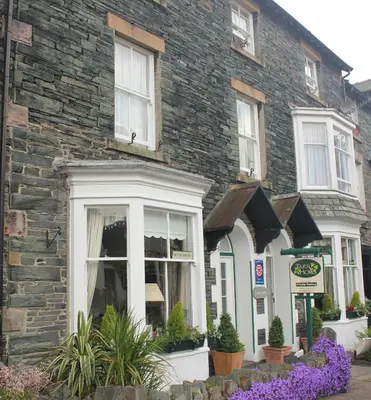 a stone house with flowers in front of it at Tarn Hows in Keswick