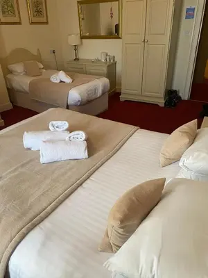 a hotel room with two beds with towels on them at George Hotel in Keswick