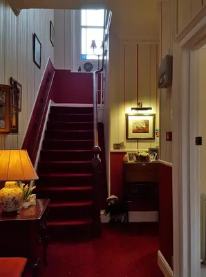 a staircase in a room with a red carpet at Dorchester House in Keswick