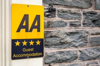a yellow and black sign on a brick wall at Dorchester House in Keswick