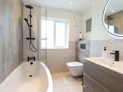 a bathroom with a tub and a toilet and a sink at Fran's Nest in Keswick