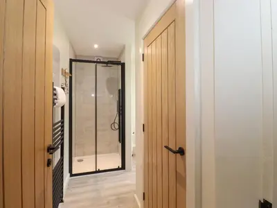 a bathroom with a shower and a glass door at Fran's Nest in Keswick