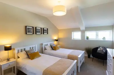 a bedroom with two beds and a window at Arran View Apartment at Heads of Ayr in Ayr