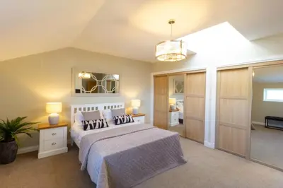 a bedroom with a bed with a white bedspread at Arran View Apartment at Heads of Ayr in Ayr