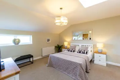 a bedroom with a bed and a window at Arran View Apartment at Heads of Ayr in Ayr