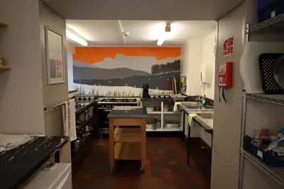 a kitchen with an orange painting on the wall at Elterwater Hostel in Elterwater