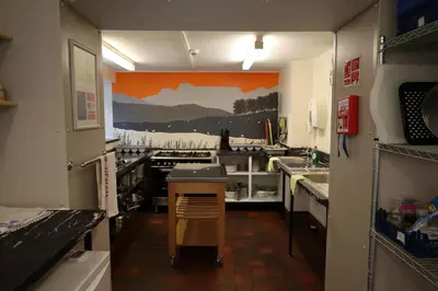 a kitchen with an orange painting on the wall at Elterwater Hostel in Elterwater