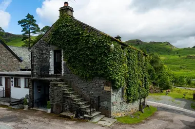 an ivy covered building with a staircase on it at Old Sawpit in Ambleside