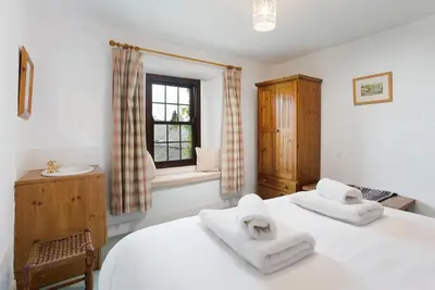 a bedroom with a bed and a sink and a window at Old Sawpit in Ambleside