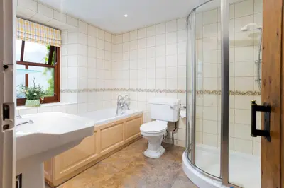 a bathroom with a tub and a toilet and a sink at Old Sawpit in Ambleside