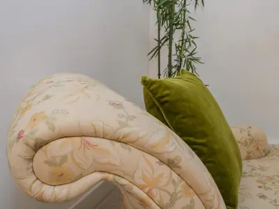 a couch with a green pillow next to a vase at The Residence in Cleator