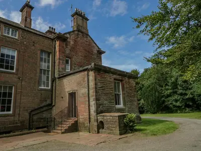 an old brick building with two chimneys on top at The Residence in Cleator