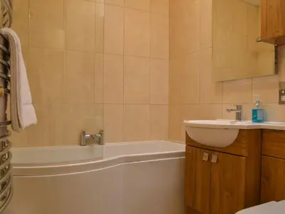 a bathroom with a bath tub and a sink at 4 Harney Peak in Portinscale