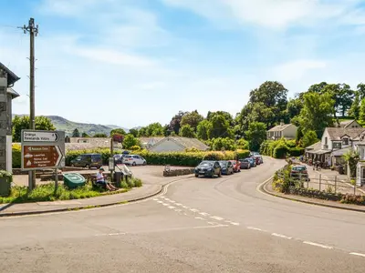 a winding road in a small town with cars parked at 4 Harney Peak in Portinscale