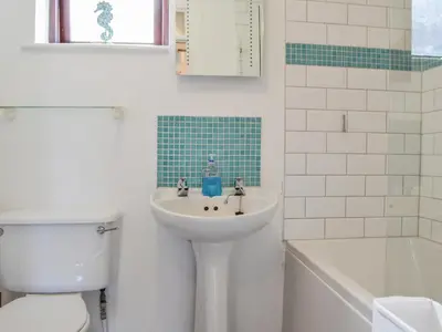 a white bathroom with a sink and a toilet at Buttermere Apartment in Keswick
