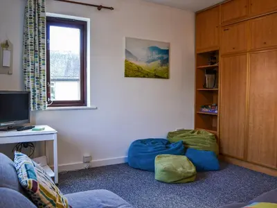 a living room with a couch and a table and a television at Buttermere Apartment in Keswick