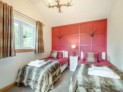 two beds in a room with red walls at Appletree Lodge in Ayr