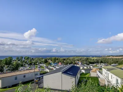 an aerial view of a small town with houses and the ocean at Appletree Lodge in Ayr