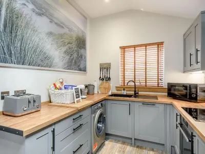 a kitchen with a sink and a washing machine at Appletree Lodge in Ayr