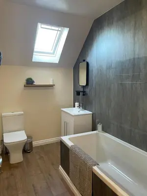 a bathroom with a tub and a toilet and a window at Cozy 2 bedroom cottage with log burner close to Loch Ken in New Galloway