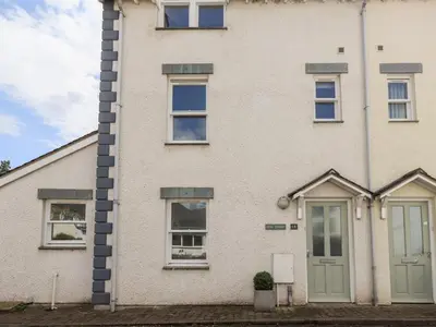 a white brick house with a green door at Fell Sweep in Keswick