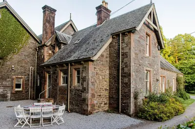 an old stone house with a table and chairs at The Stables in Castle Douglas