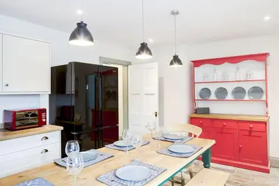 a kitchen with a wooden table and red cabinets at Blairinnie in Castle Douglas