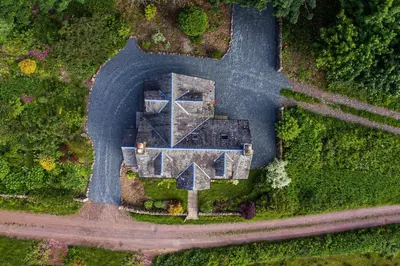an aerial view of a house in the middle of a road at Culdoach in Castle Douglas