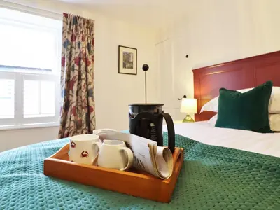 a tray with a coffee maker and mugs on a bed at Union Street in Kirkcudbright