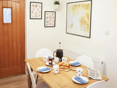 a dining room with a wooden table and chairs at Union Street in Kirkcudbright