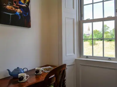 a dining room table with a vase and a window at Craigvar House in Castle Douglas