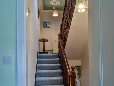 a stairway with a wooden rail and blue stairs at Craigvar House in Castle Douglas