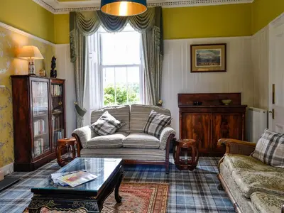 a living room with a couch and a table at Craigvar House in Castle Douglas