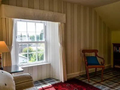 a room with a chair and a window at Craigvar House in Castle Douglas