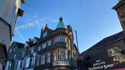 a large building with a green turret on a street at Grandy Nook in Keswick