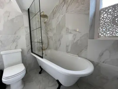 a bathroom with a tub and a toilet and a sink at Shelley Cottage in Keswick