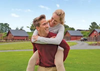 a man carrying a woman on his back at Nunland Hillside Lodges in Lochfoot