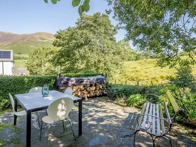a patio with a table and chairs in a yard at 1, The Barns in Threlkeld