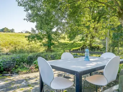 a table and chairs in a garden with a tree at 1, The Barns in Threlkeld