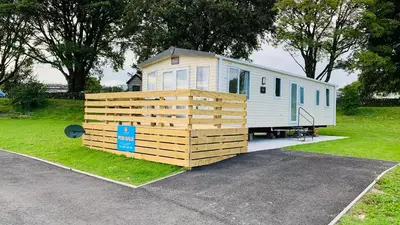 a tiny house is parked in a parking lot at HV66 - FREE WIFI-3 Bedrooms Indoor Pool Loch Views Fishing Golf Riding Shooting Water Sports 15 Mins Drive To Beaches PASSES NOT INCLUDED Most Activities Will Not Be Available Out Of Season Please Check Before Booking in Newton Stewart