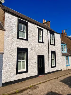 a white house with black windows and a door at Character cottage in centre of Moffat in Moffat