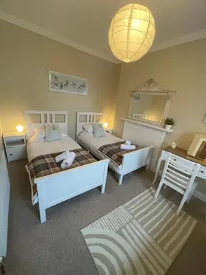 a bedroom with two beds and a table and a lamp at Character cottage in centre of Moffat in Moffat