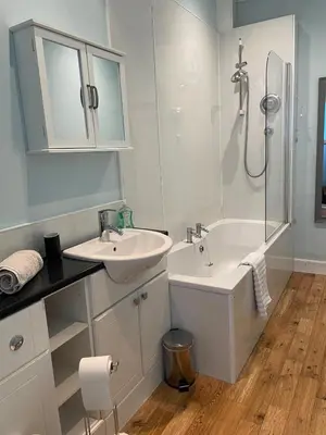 a white bathroom with a sink and a shower at Character cottage in centre of Moffat in Moffat