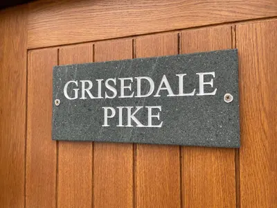 a sign on a wooden door with the words crazed pulse at Grisedale Pike in Keswick