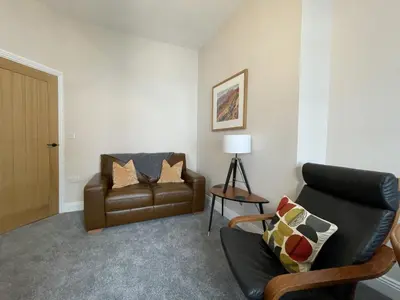 a living room with a couch and a chair at Grisedale Pike in Keswick