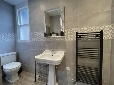 a bathroom with a sink and a toilet and a mirror at Grisedale Pike in Keswick