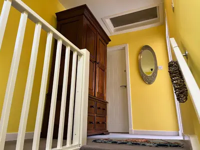 a room with a staircase and a mirror on the wall at St John's Town of Dalry Glentress Apartment 1 in Dalry
