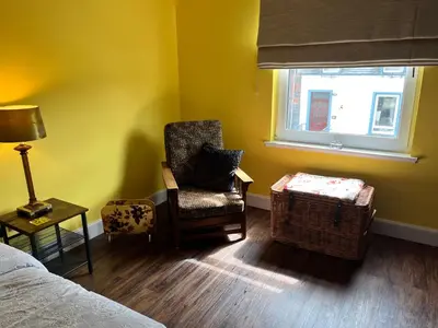 a living room with a chair and a window at St John's Town of Dalry Glentress Apartment 1 in Dalry