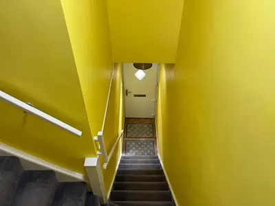 a hallway with a yellow wall and stairs at St John's Town of Dalry Glentress Apartment 1 in Dalry